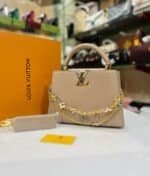 Beige structured top-handle bag with floral chains and matching strap