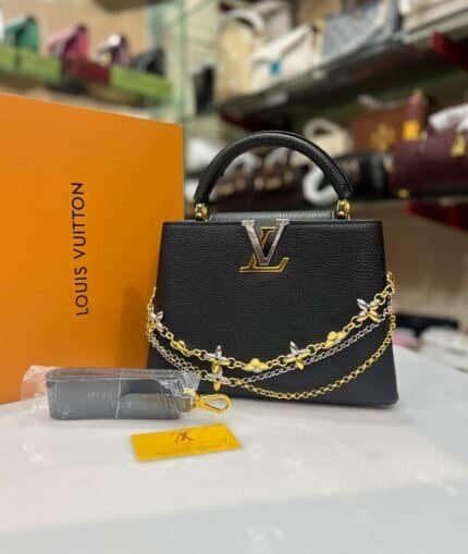 Black structured top-handle bag with floral chains and matching strap